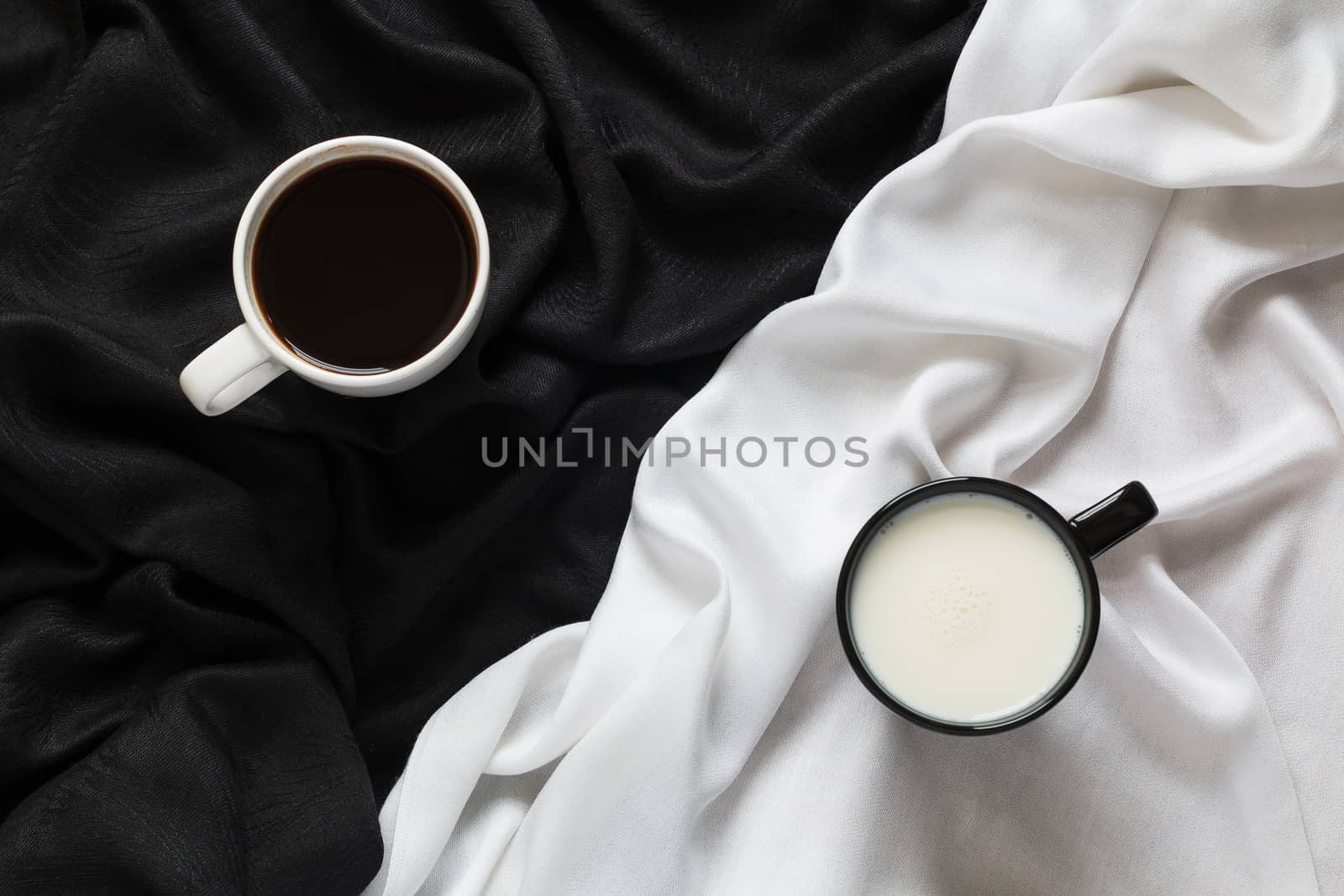 2 cups of coffee and milk on the black and white fabric. Top view