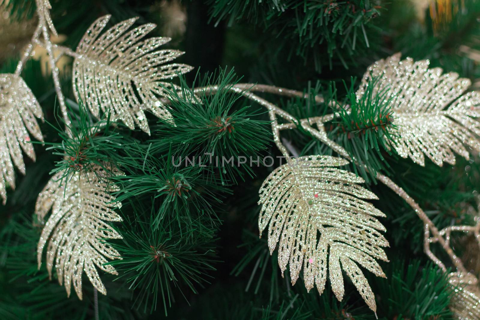 Christmas and New Year seasonal background of green tree branches with bright golden leaves garlands and ornaments