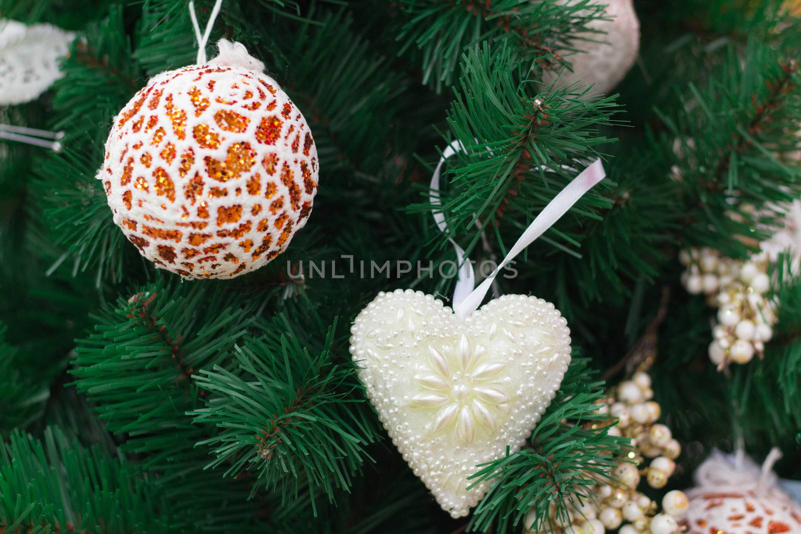 Christmas and New Year seasonal decoration, green tree branches with orange ball and white heart ornaments