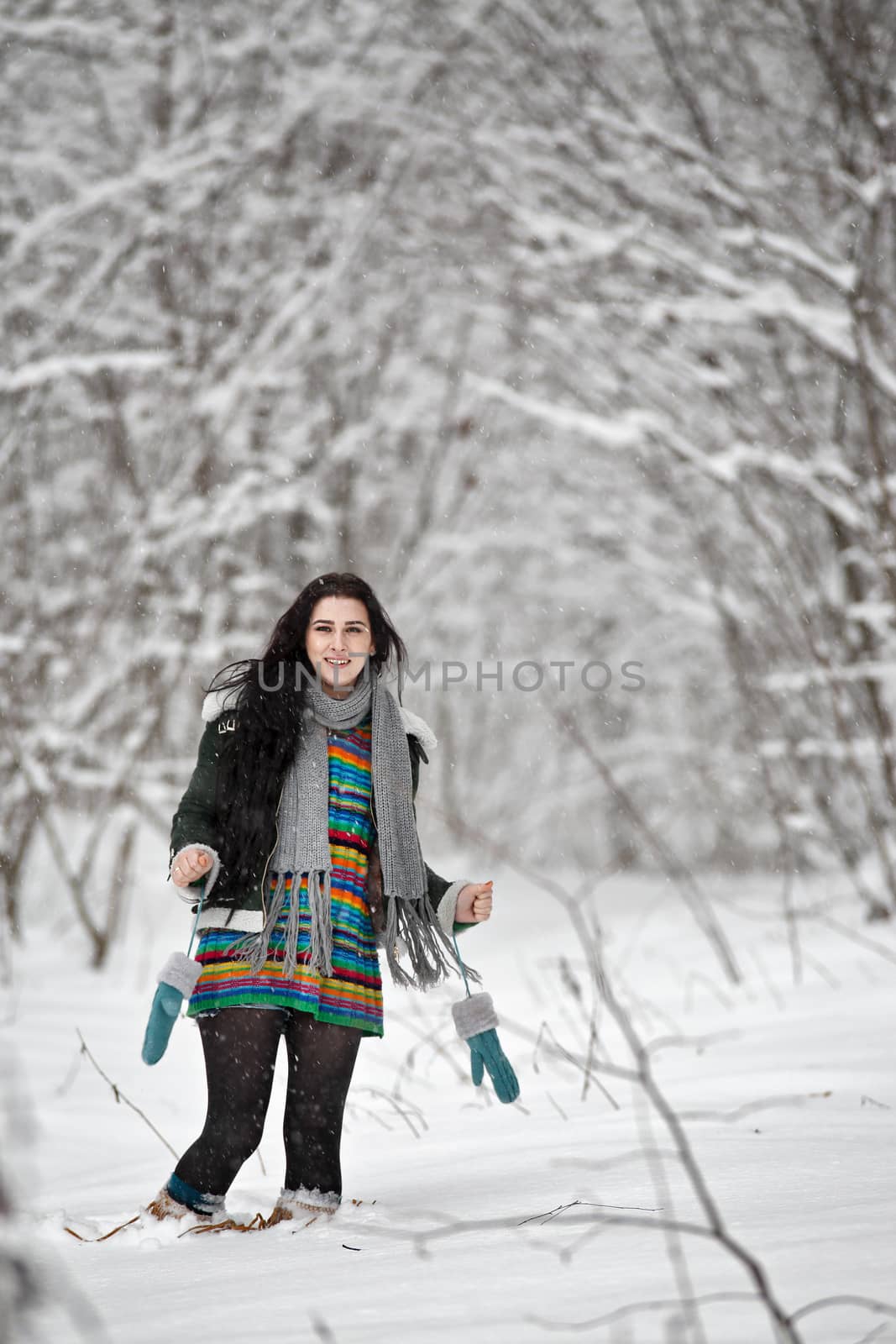 Beautiful young woman in a sweater on a winter walk in a forest. Looking At Camera