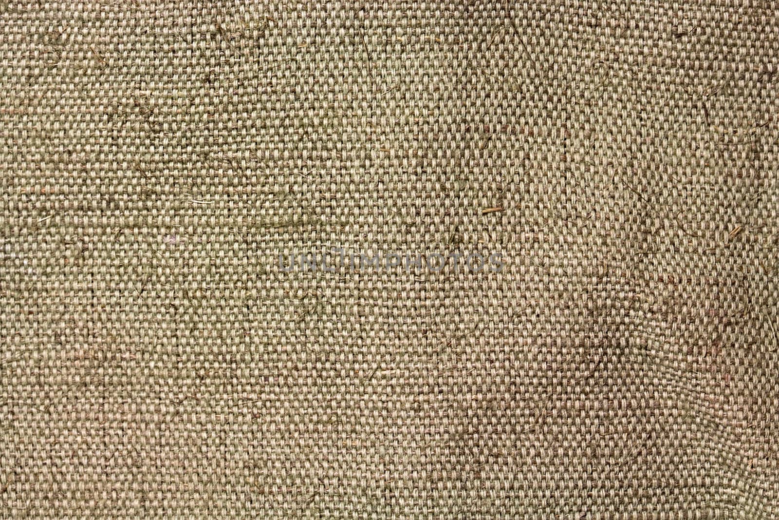 A piece of tarpaulin. The texture of coarse fabric with interwoven threads. Uneven surface. Close-up image for retro backgrounds or texturing.