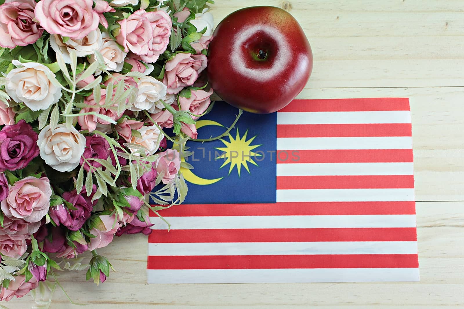 National day : Malaysia flag, apple and flower on wood background