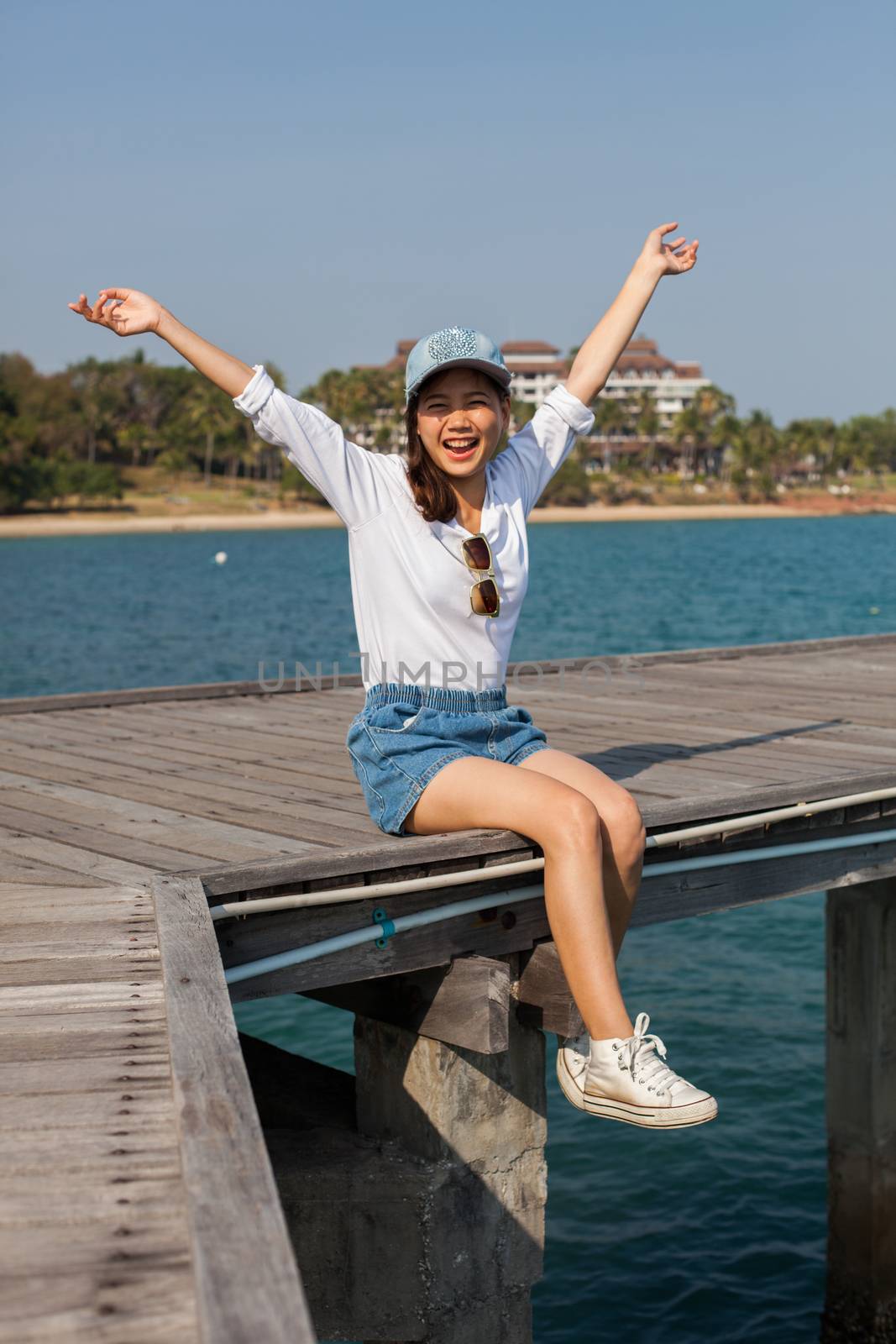 asian younger woman happiness emotion at sea side traveling dest by khunaspix