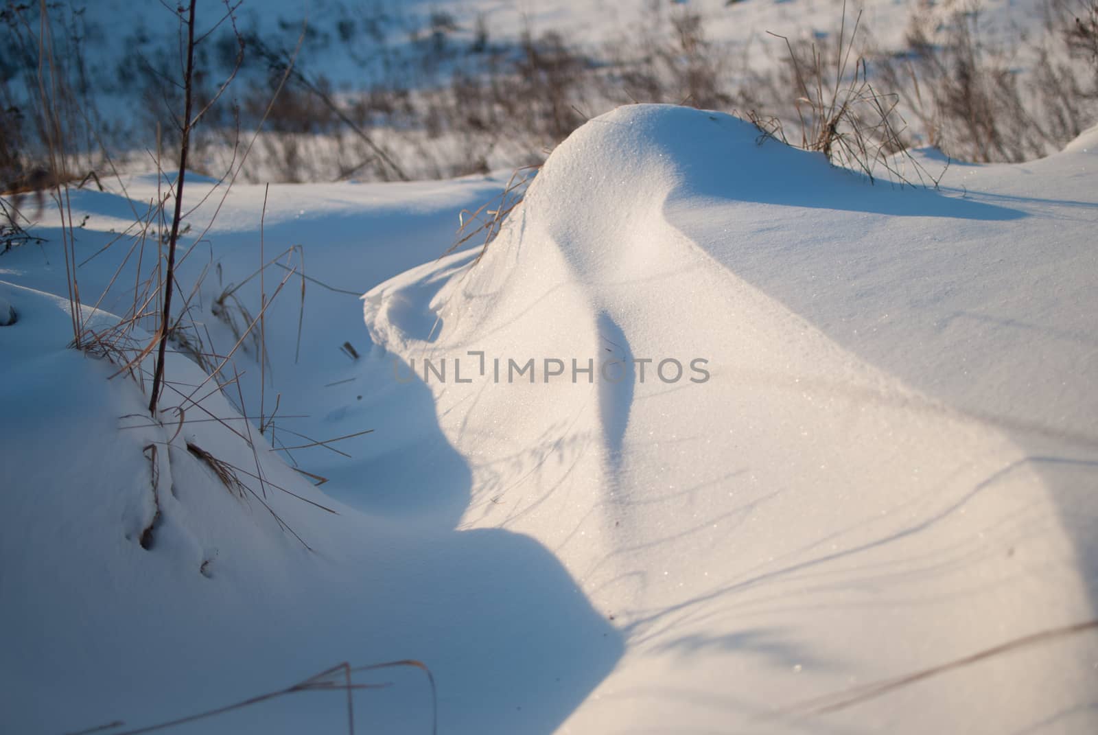 Beautiful winter landscape with snow-covered hills at sunset by skrotov