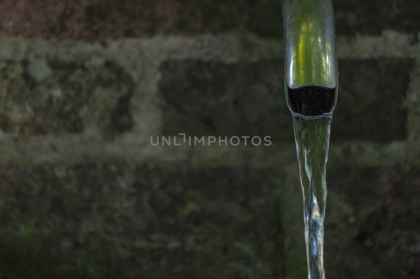 Close up of running water from a metal tap by evolutionnow