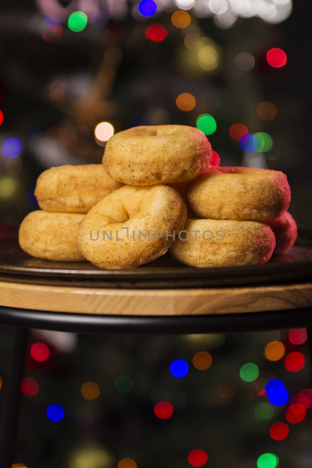 Fresh baked cinnamon donuts on a rustic metal baking tray.