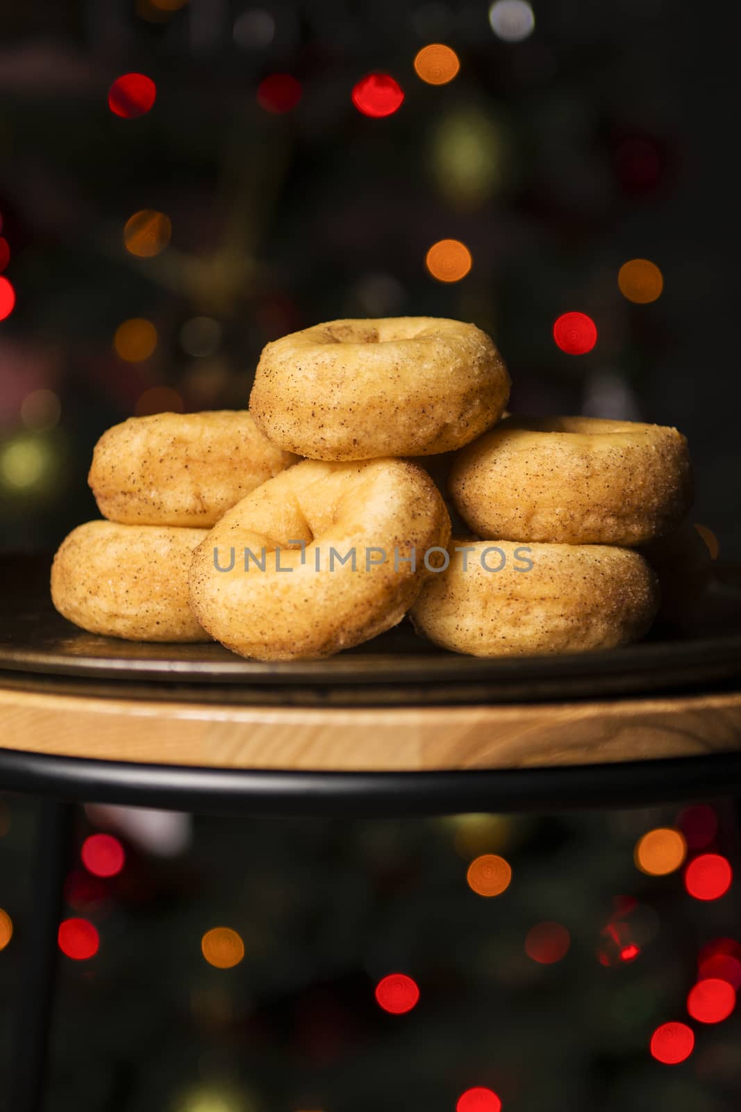 Fresh baked cinnamon donuts on a rustic metal baking tray.