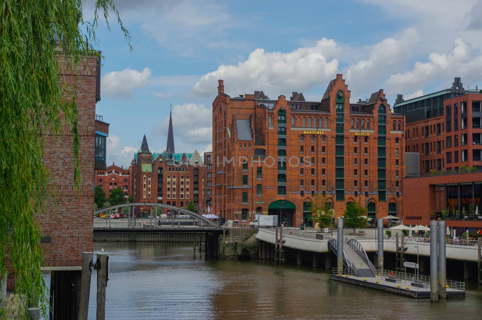 HAMBURG, GERMANY - JULY 18, 2015: a canal of Historic Speicherstadt houses and bridges at evening with amaising skyview over warehouses, famous place on Elbe river.