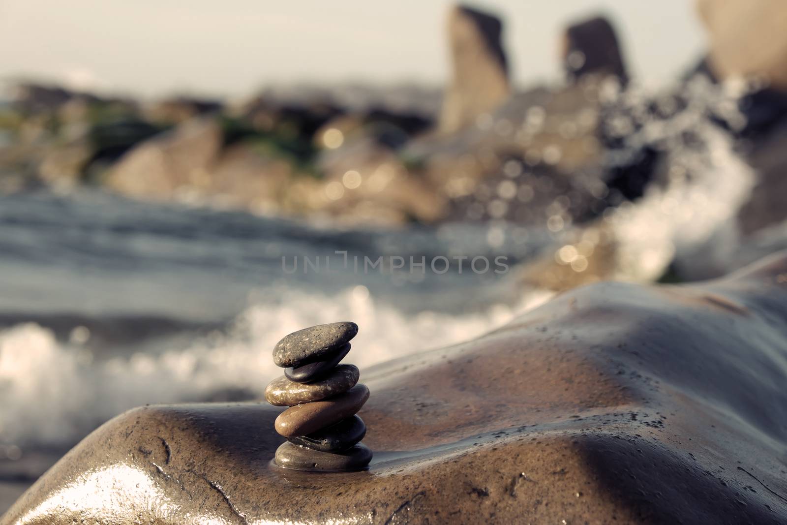 Amazing stack of stones at seaside beach, group of pebble balance on large rock as meditation, concept for Zen or strong mind or teamwork spirit