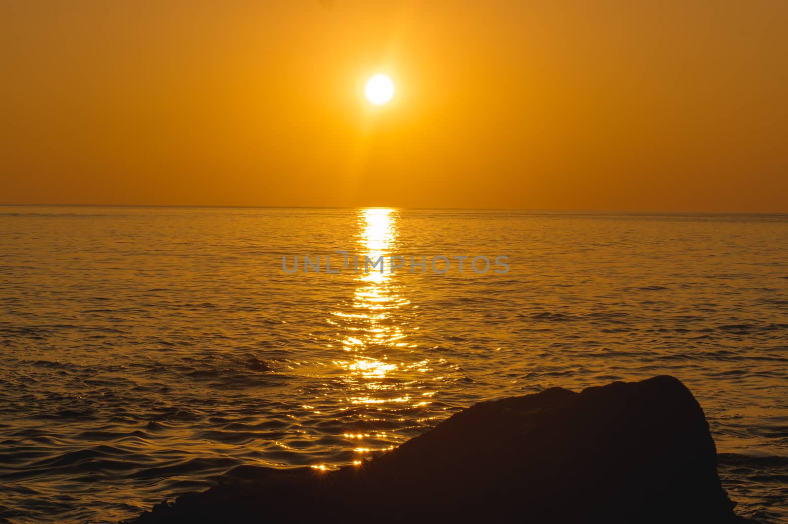 amazing tropical orange sunset over water, with rock silhouettes on Phuket Island, Thailand, by evolutionnow