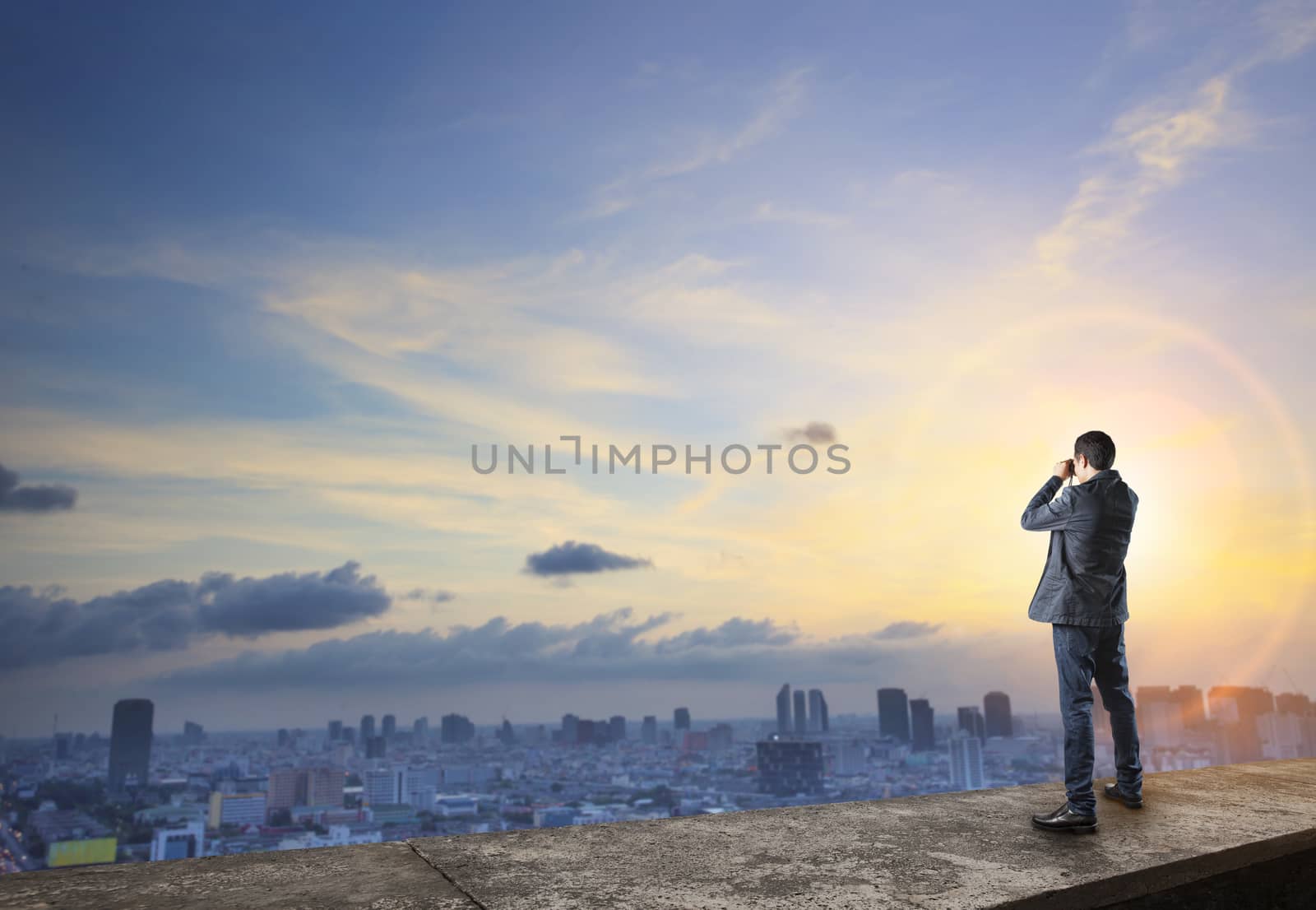 business man and binocular spying on top of building  wiht urban scene