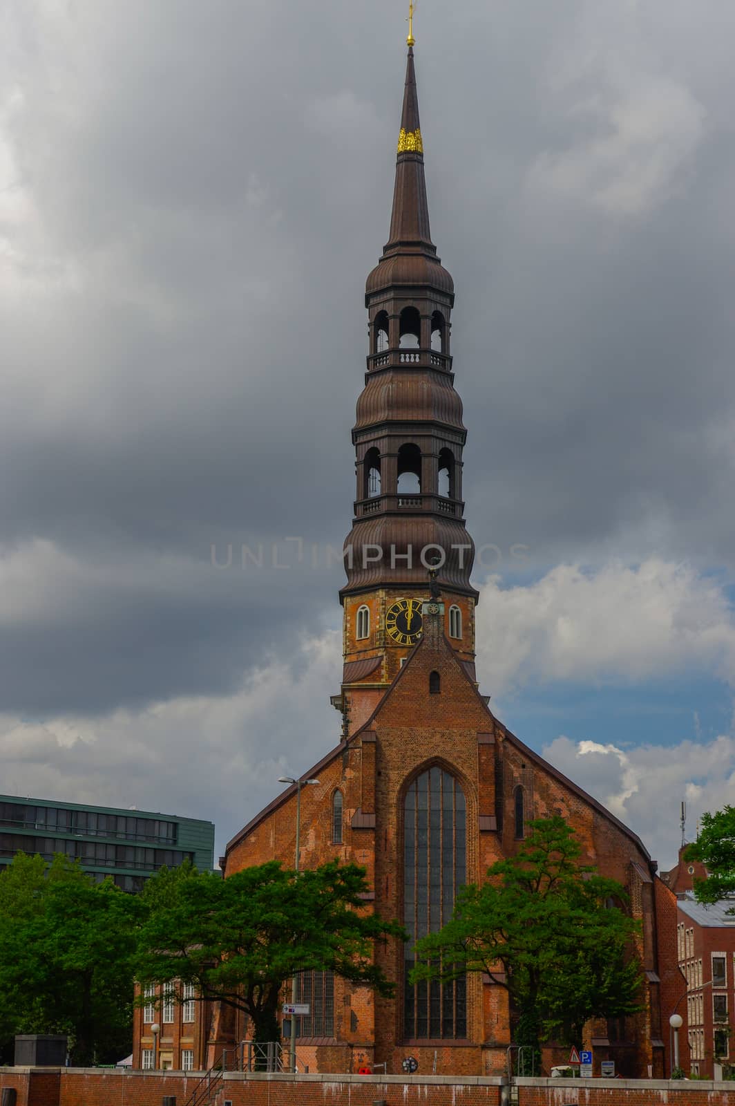 Hamburg, Germany - July 18, 2016: Warehouse District or Speicherstadt with old Church on the elb river at cloudy day.