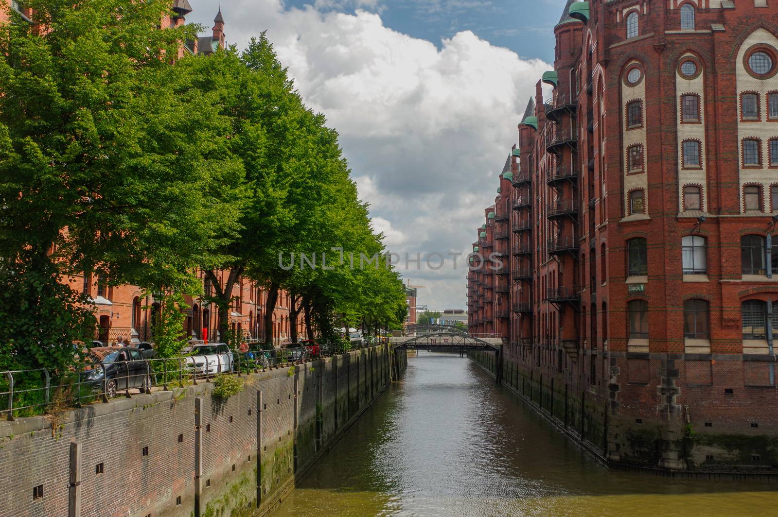 HAMBURG, GERMANY - JULY 18, 2015: the canal of Historic Speicherstadt houses and bridges at evening with amaising skyview over warehouses, famous place Elbe river. by evolutionnow