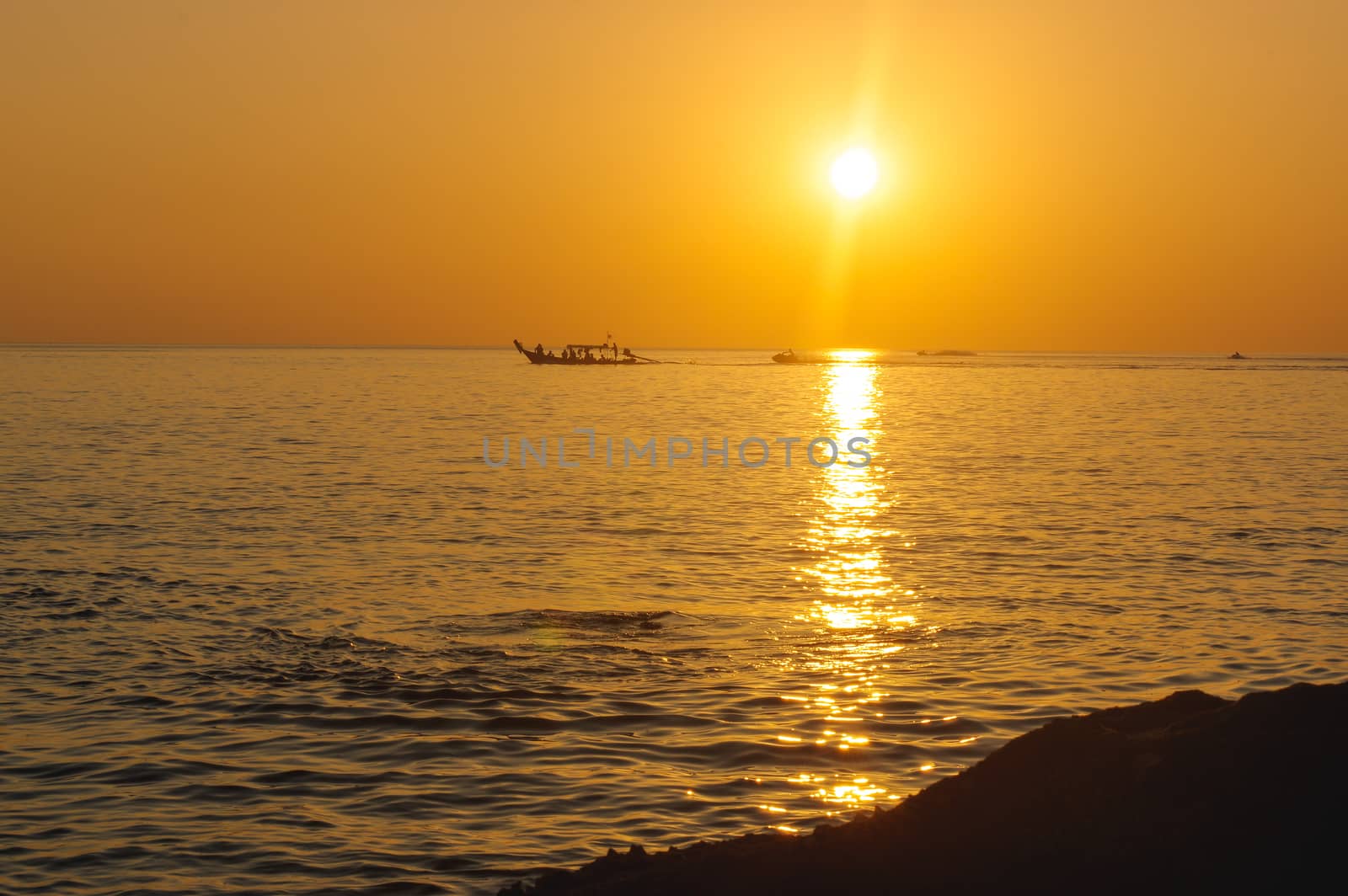 amazing tropical orange sunset over water, with rock silhouettes on Phuket Island, Thailand, by evolutionnow