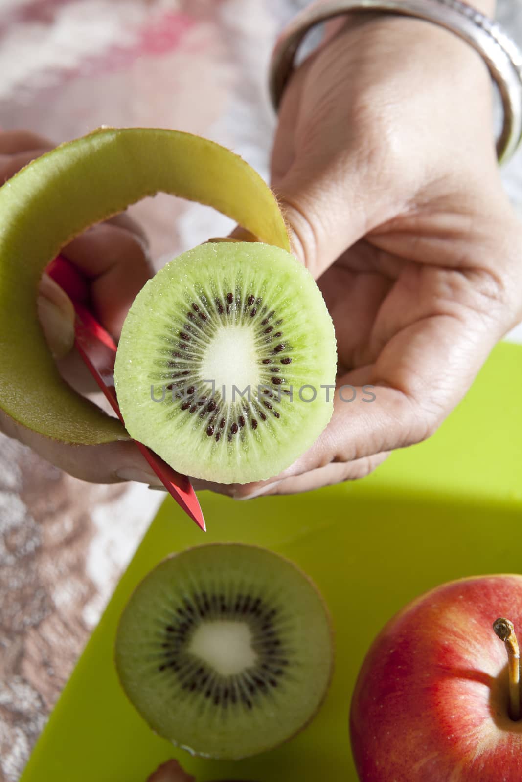 hand hold kiwi fruit  and sliced open peel for eating