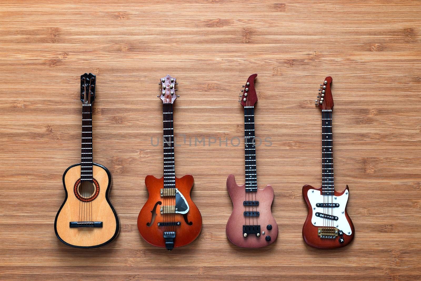 Set of four guitars on a wooden background