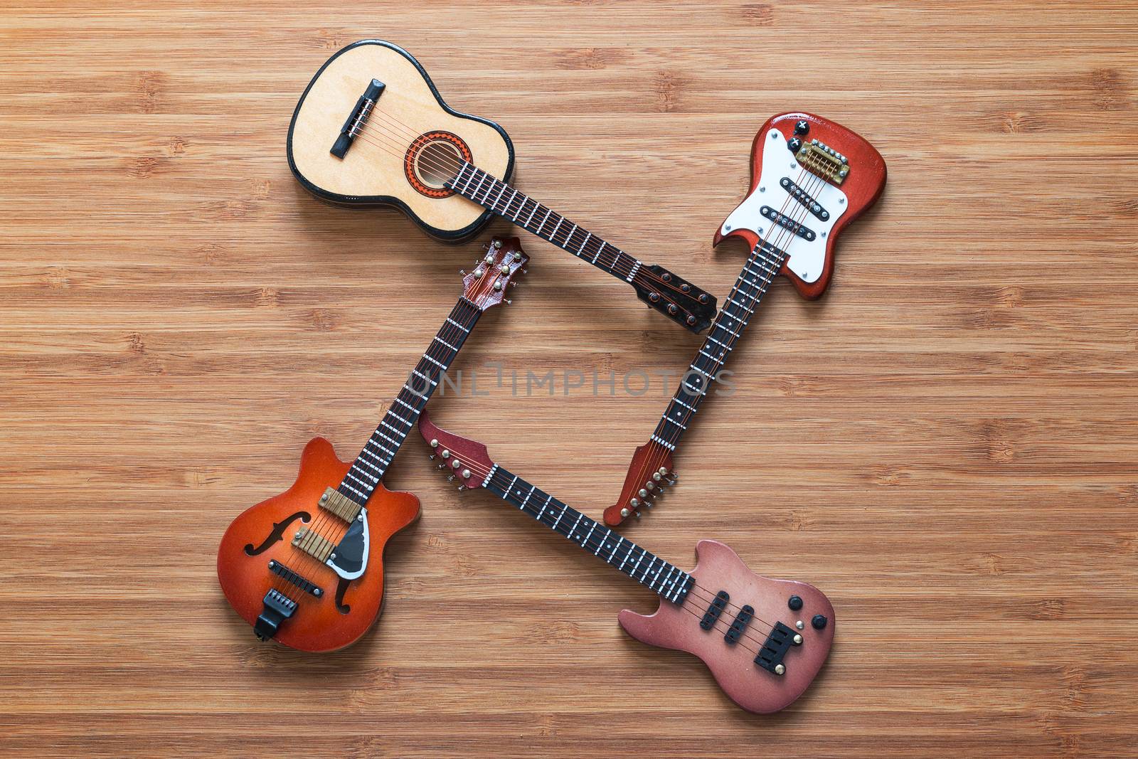 Set of four guitars on a wooden background