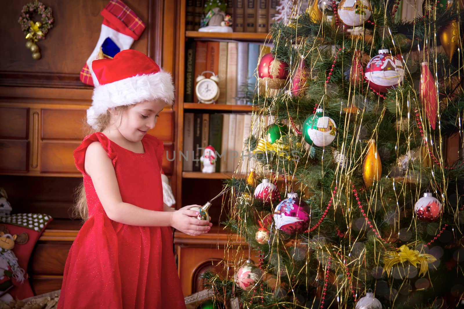 Girl with ball admiring Christmas tree