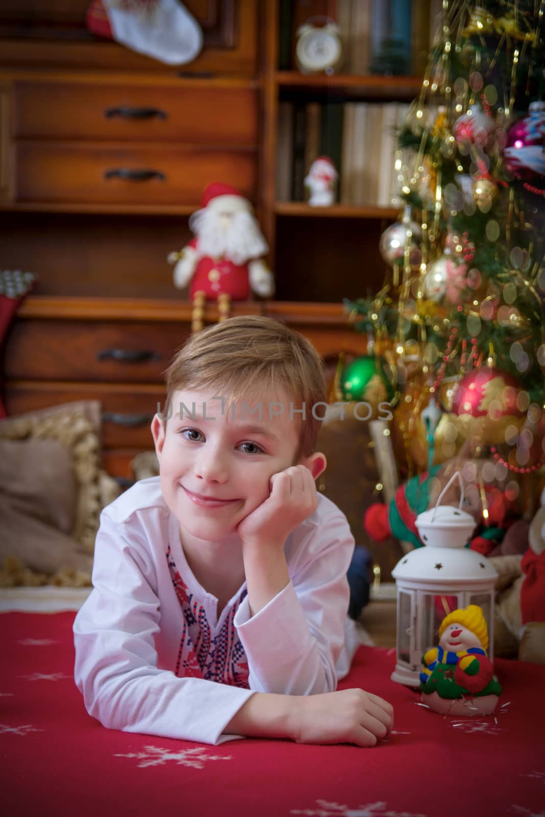 Pretty boy lying under Christmas tree