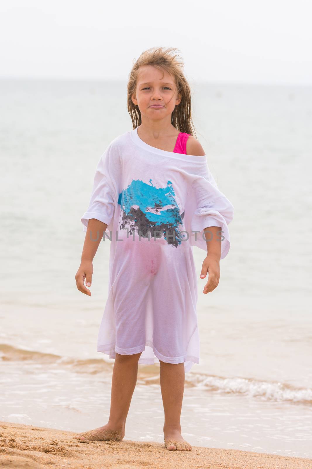 Girl poses funny faces standing on the beach in my father's shirt by Madhourse