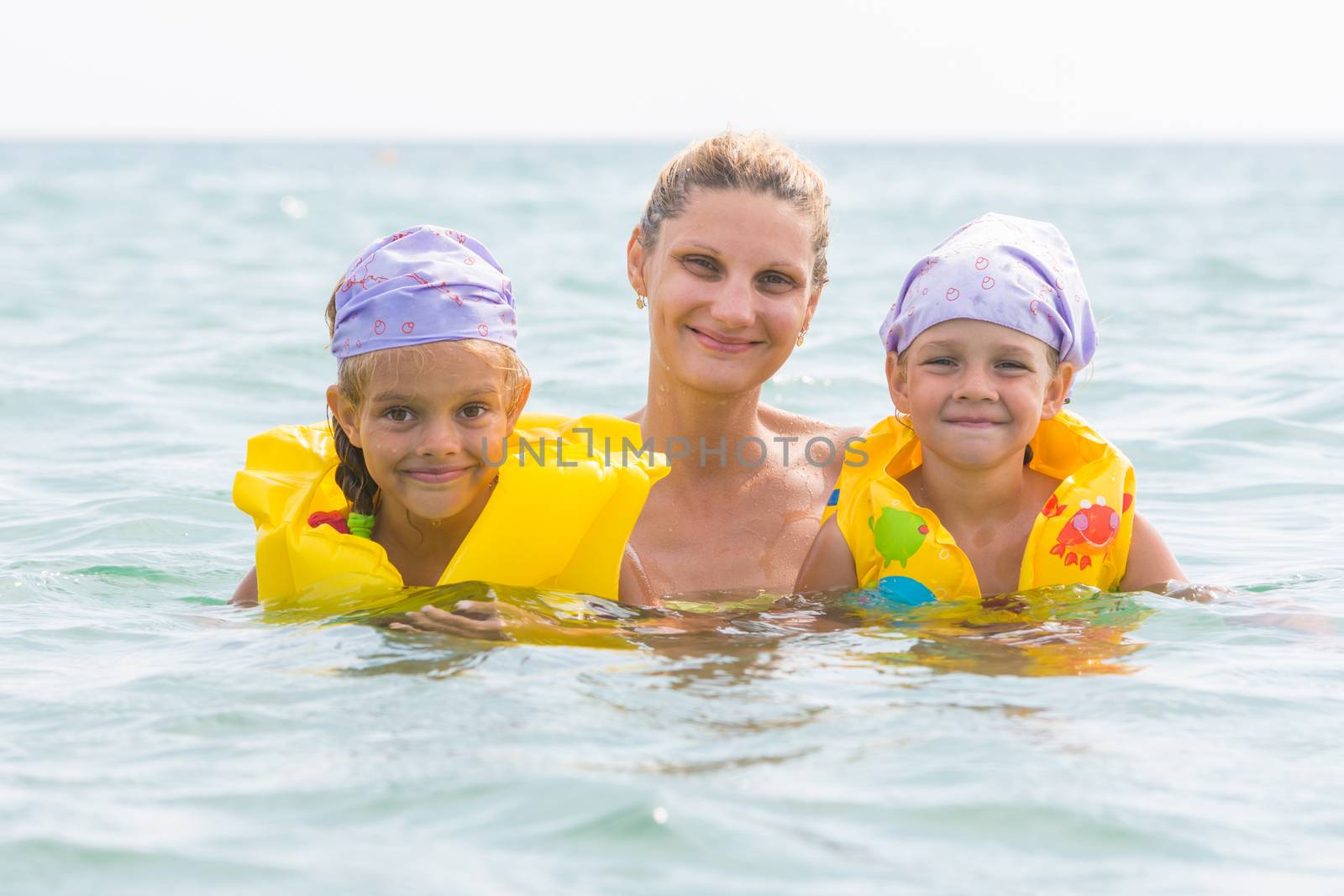 Mother and two daughters swimming in the sea by Madhourse