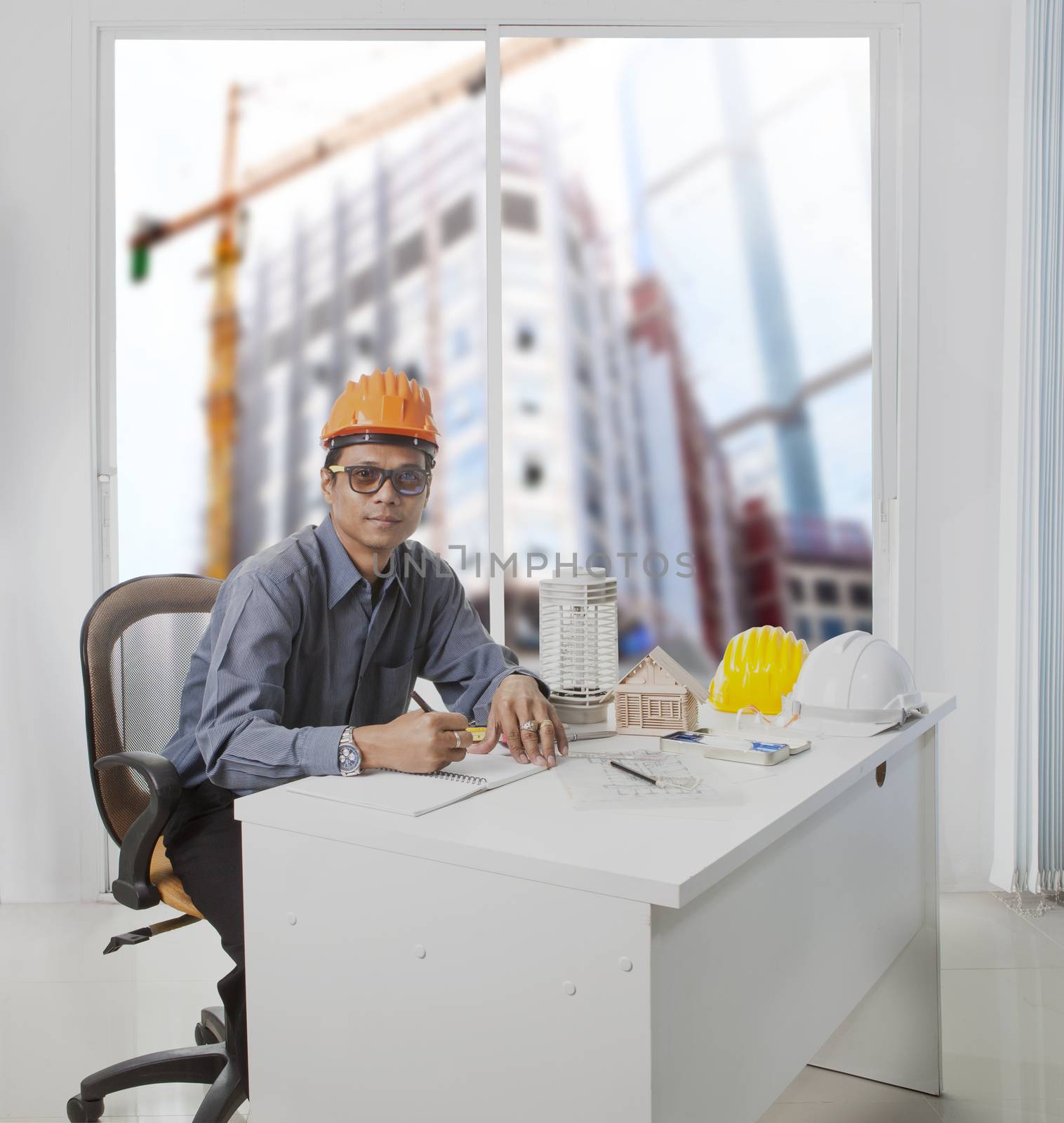 architect engineer working in office room against building construction through mirror window  use for architecture and engineering construction industry business theme and real estate land management
