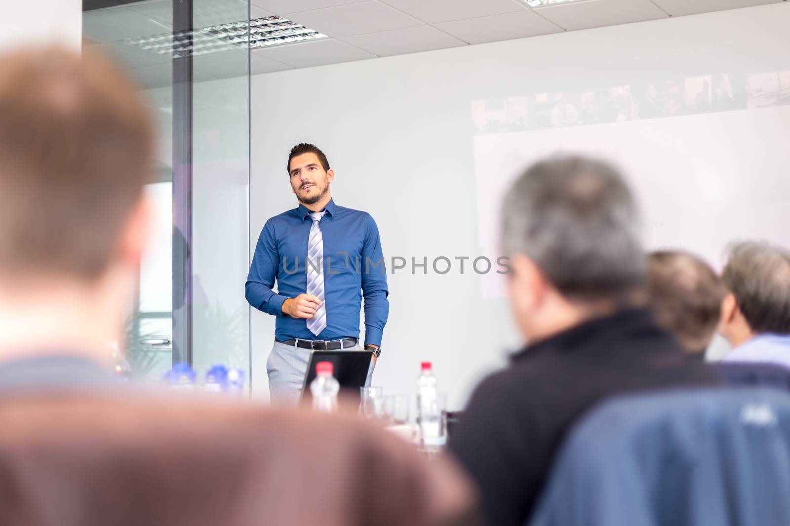 Business man making a presentation at office. Business executive delivering a presentation to his colleagues during meeting or in-house business training, explaining business plans to his employees.