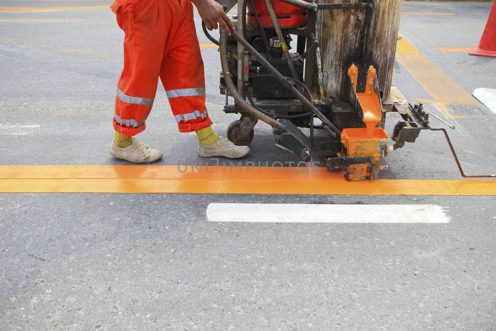 machine and worker at road construction use for road and traffic sign painting 