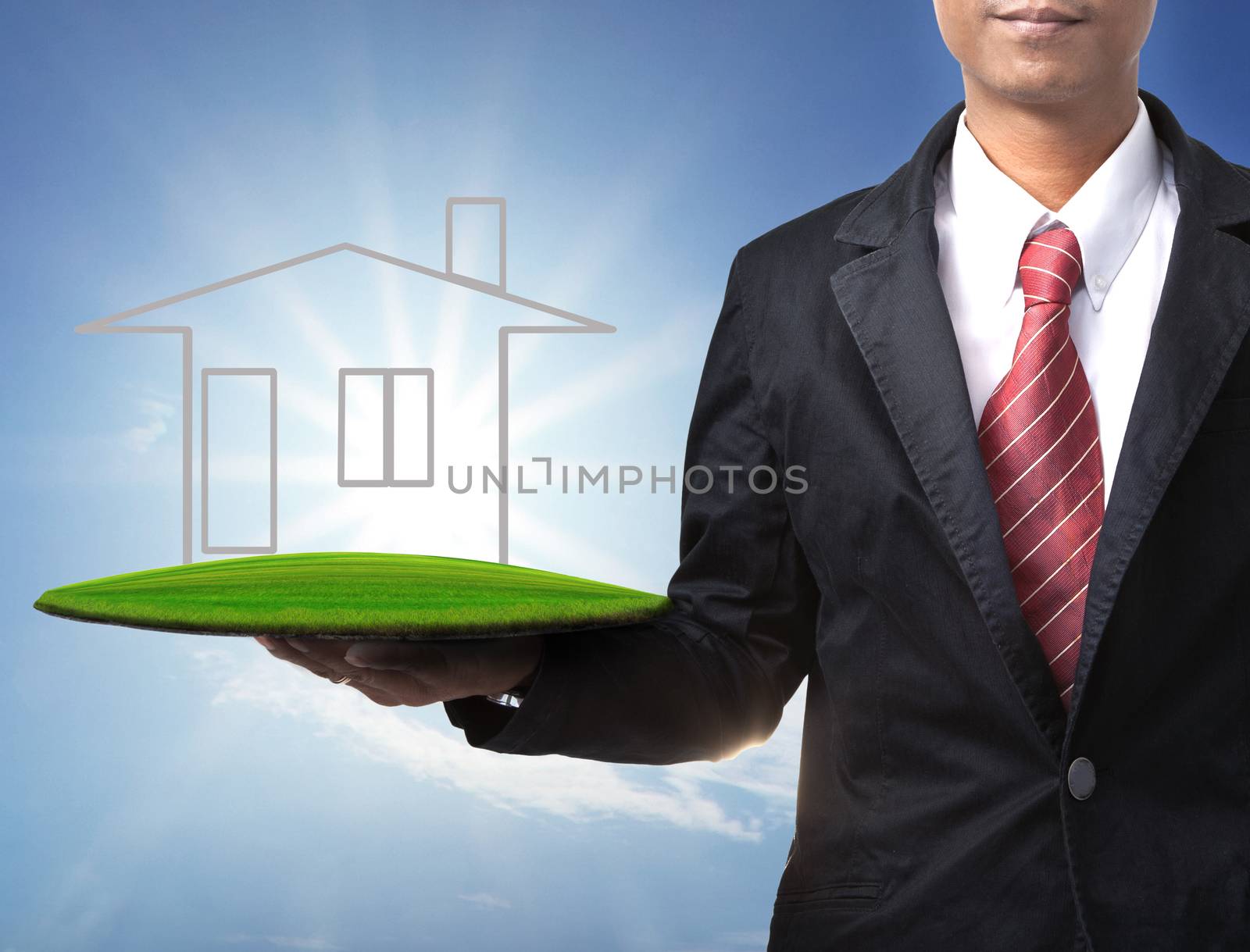 business man and home on green land in hand for multipurpose