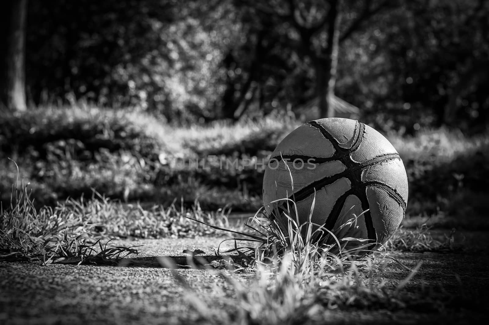 Old basketball in country playground in black and white by replica