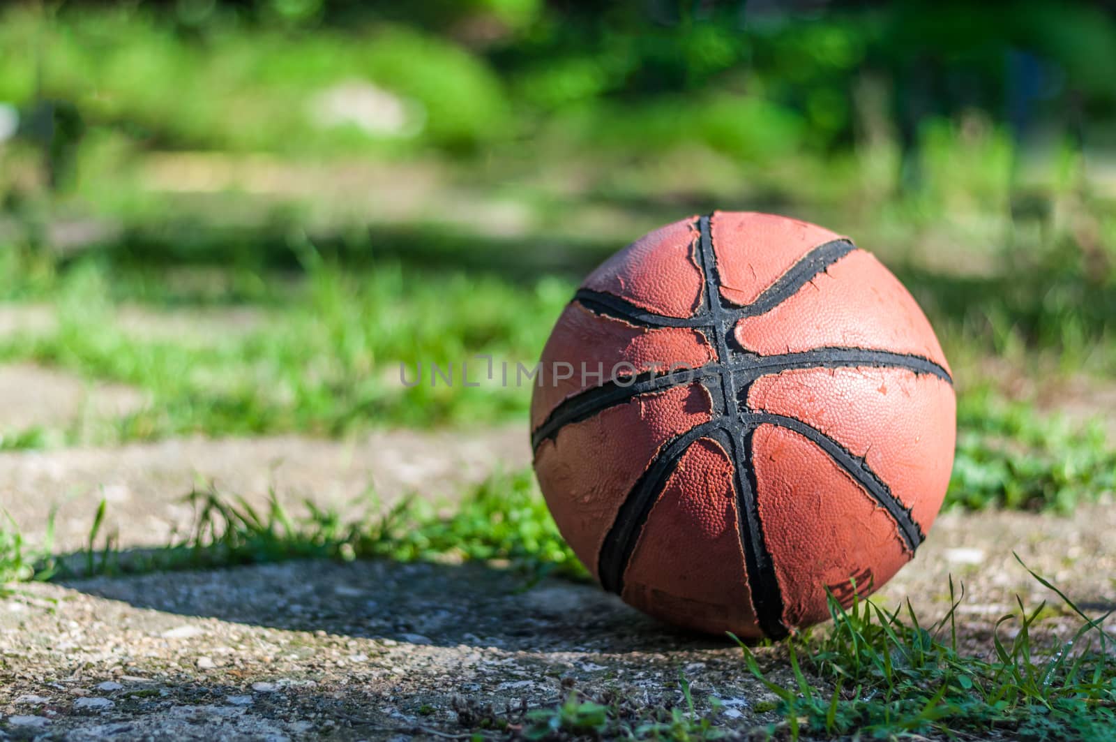 Used basketball in country playground in a sunny morning