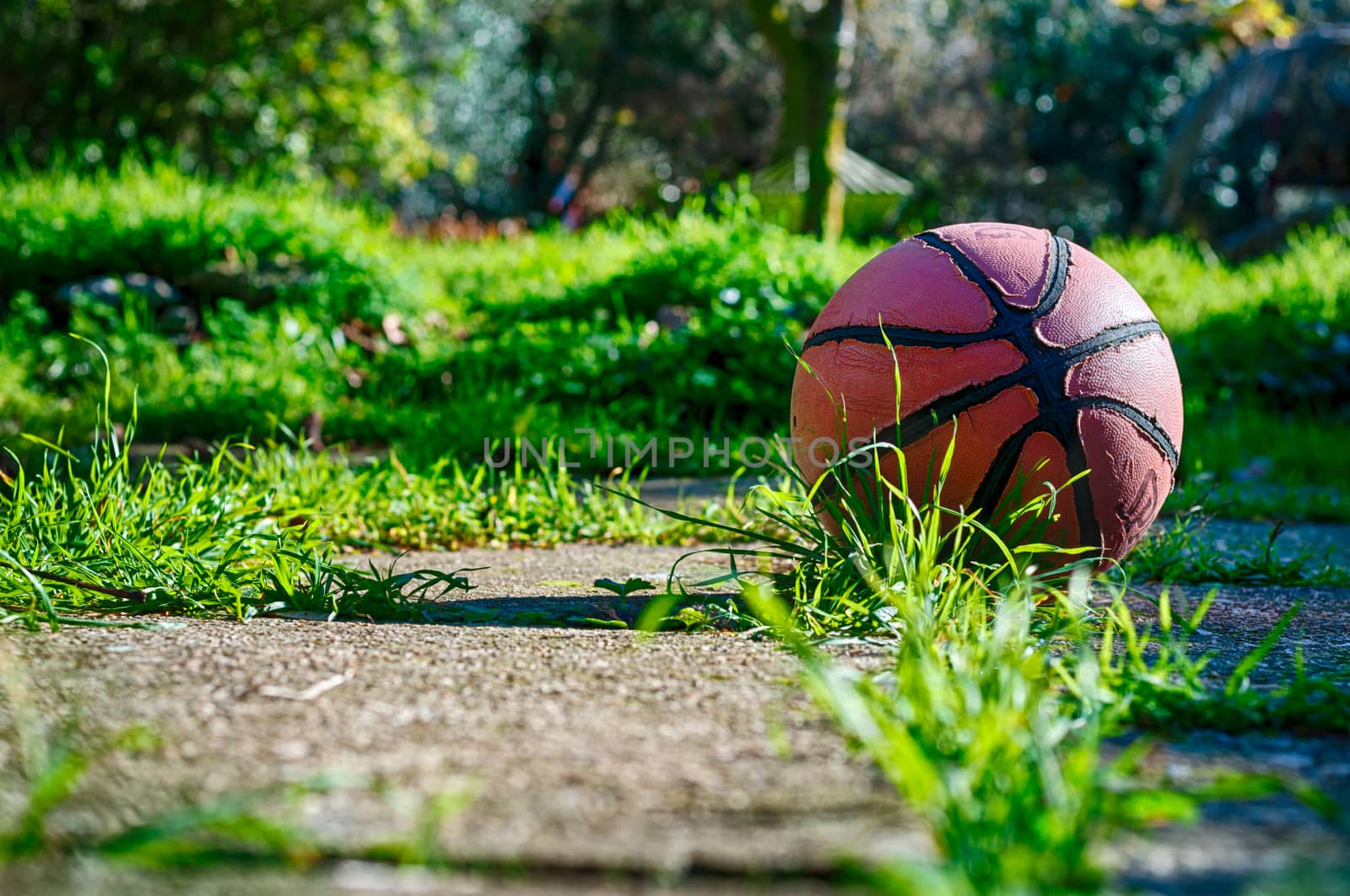 Used basketball in country playground in a sunny morning