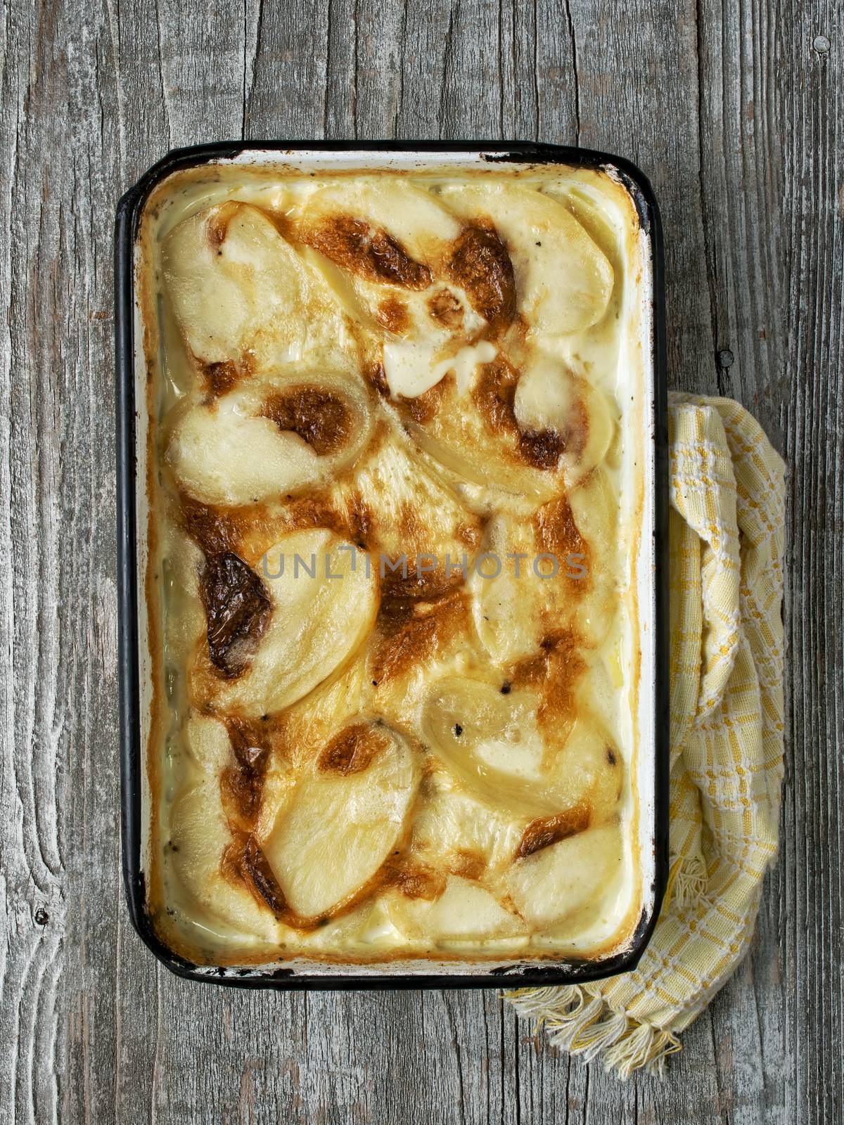 close up of rustic golden scalloped potato gratin dauphinois