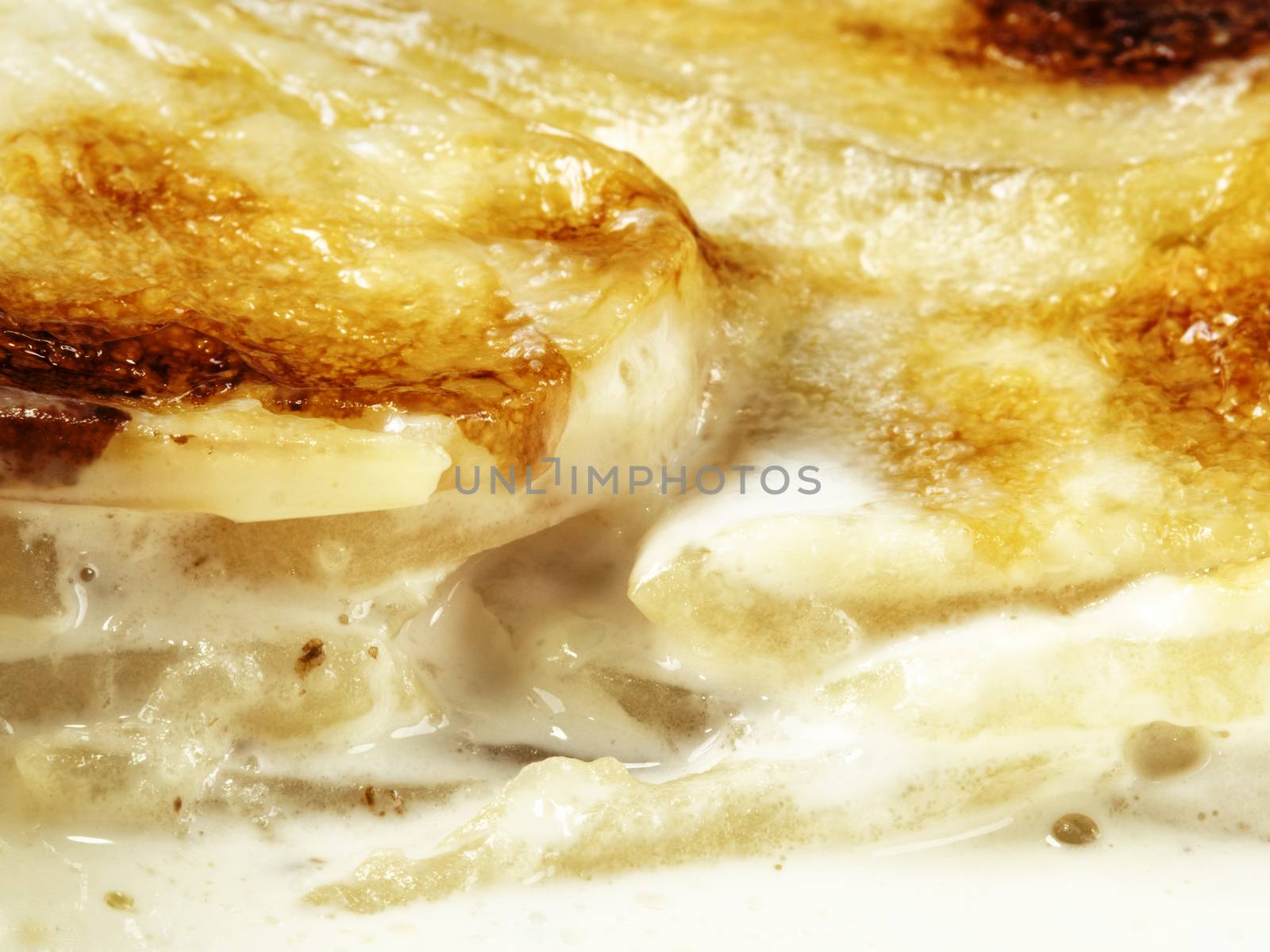 close up of rustic golden scalloped potato gratin dauphinois