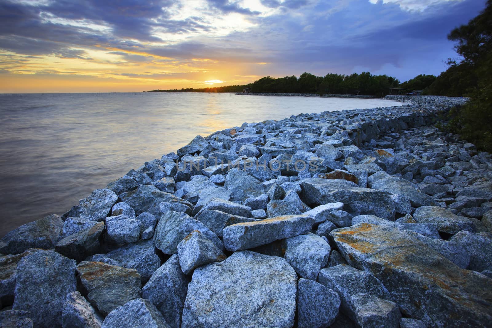 sun set with rock dam sea coast bank protection perspective line