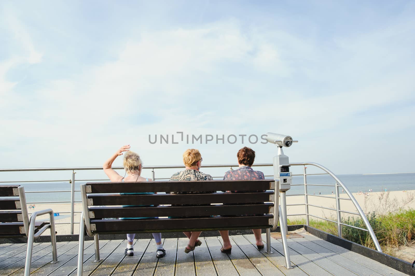 tourists sit on a bench at the beach