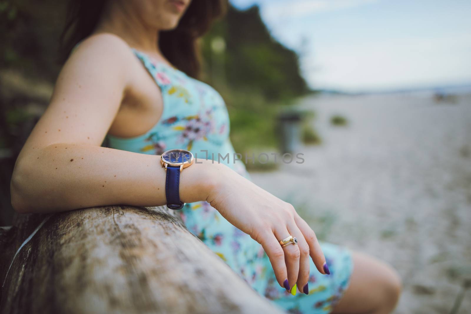 Young attractive brunette woman on a beach wearing dress