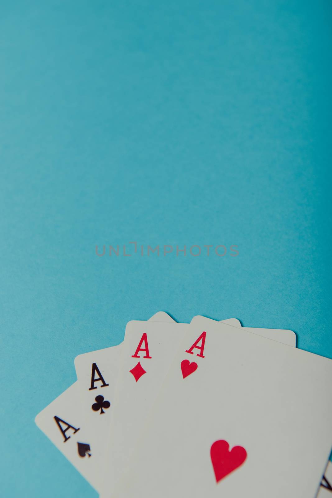 A winning poker hand of four aces playing cards on blue background