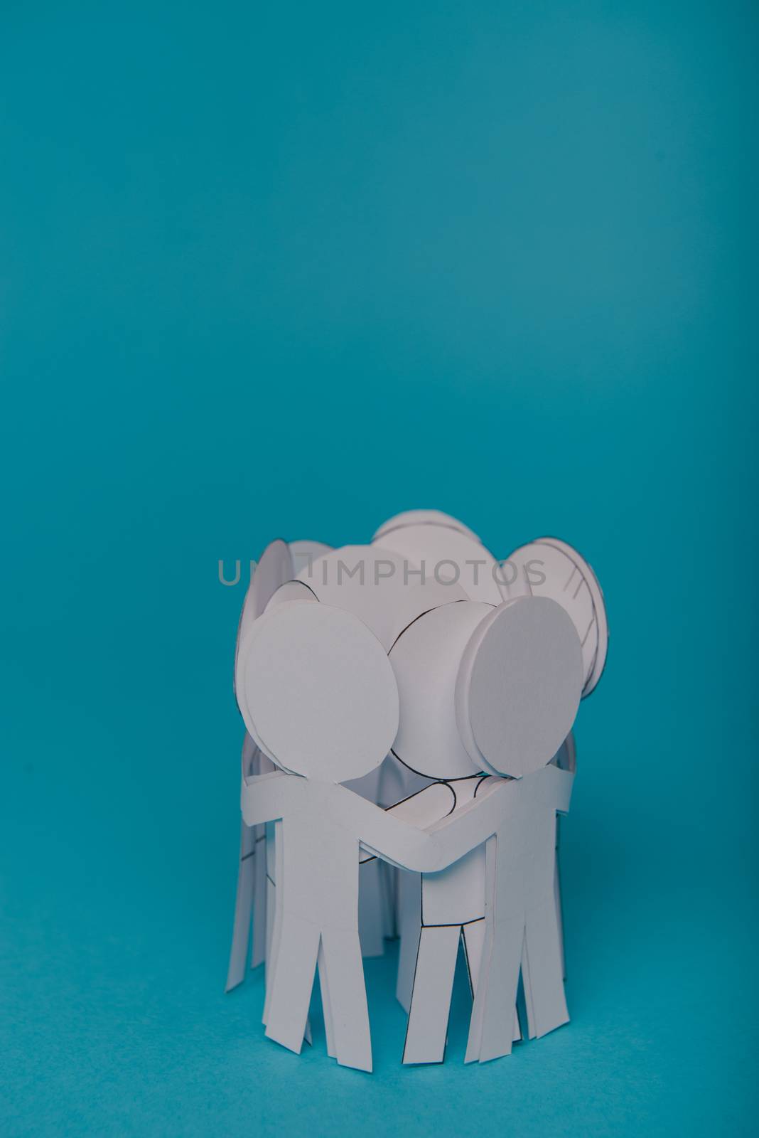 abstract paper people holding for hands on blue background