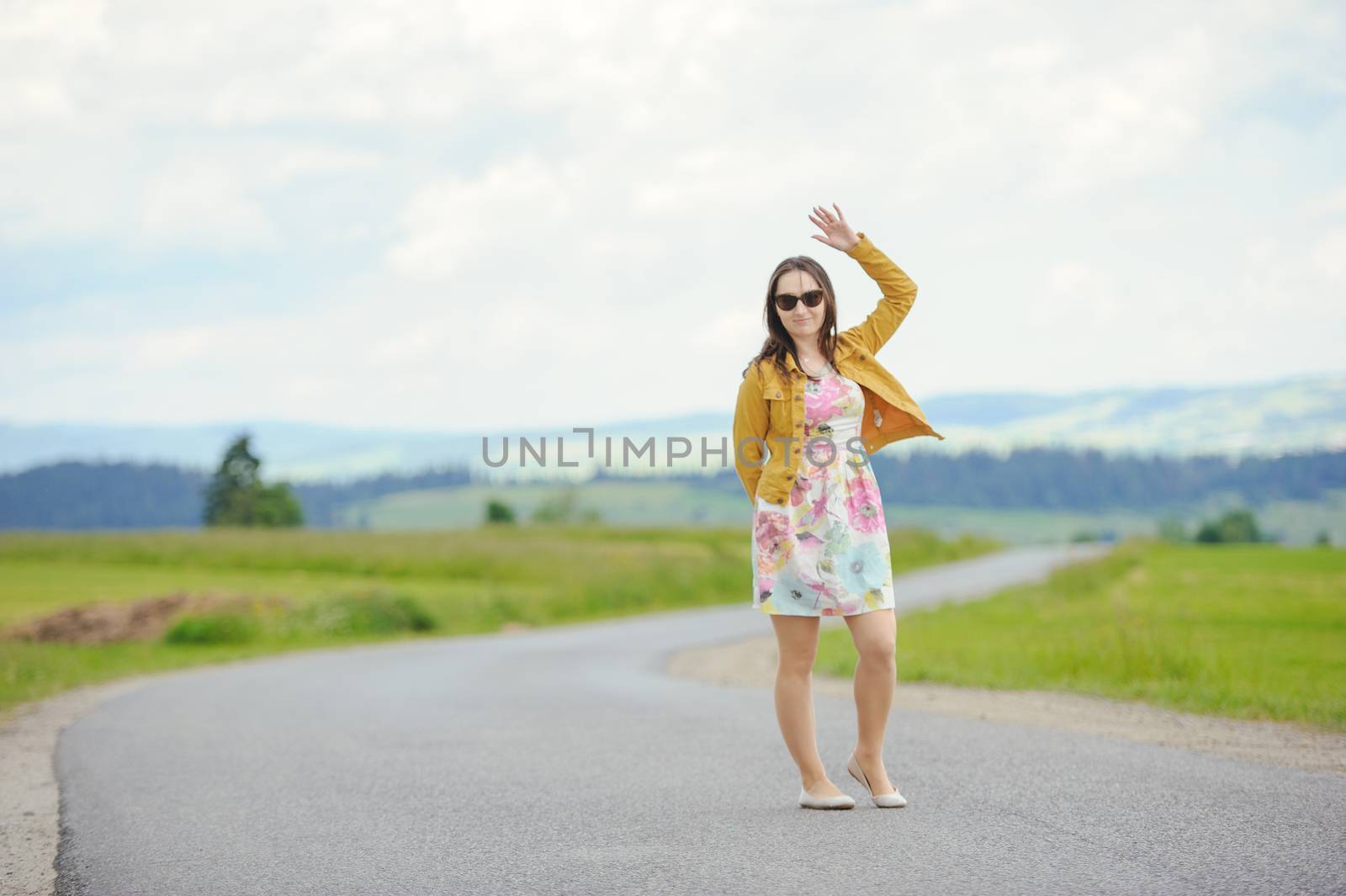 girl standing on asphalt country road in the mountains