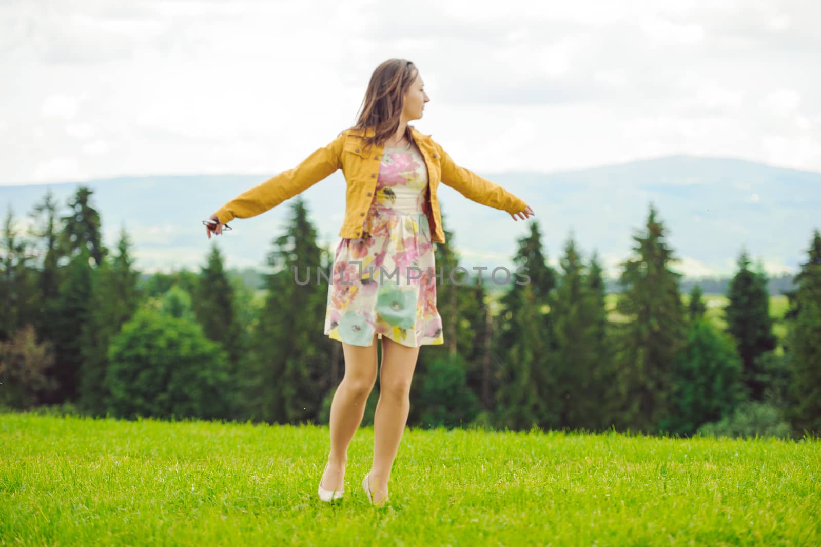 Beautiful Young Woman Outdoors. Smiling Girl in Green Grass.