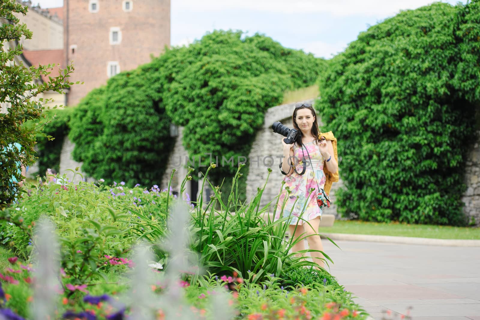 Female tourist takes picture in historic city in Cracow, Poland.