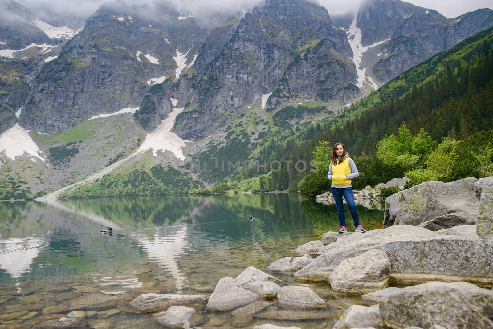 woman relaxing on the lake and mountains sunny landscape.