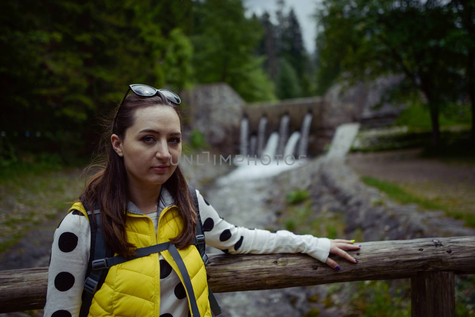 Woman walking over wooden bridge in summer time
