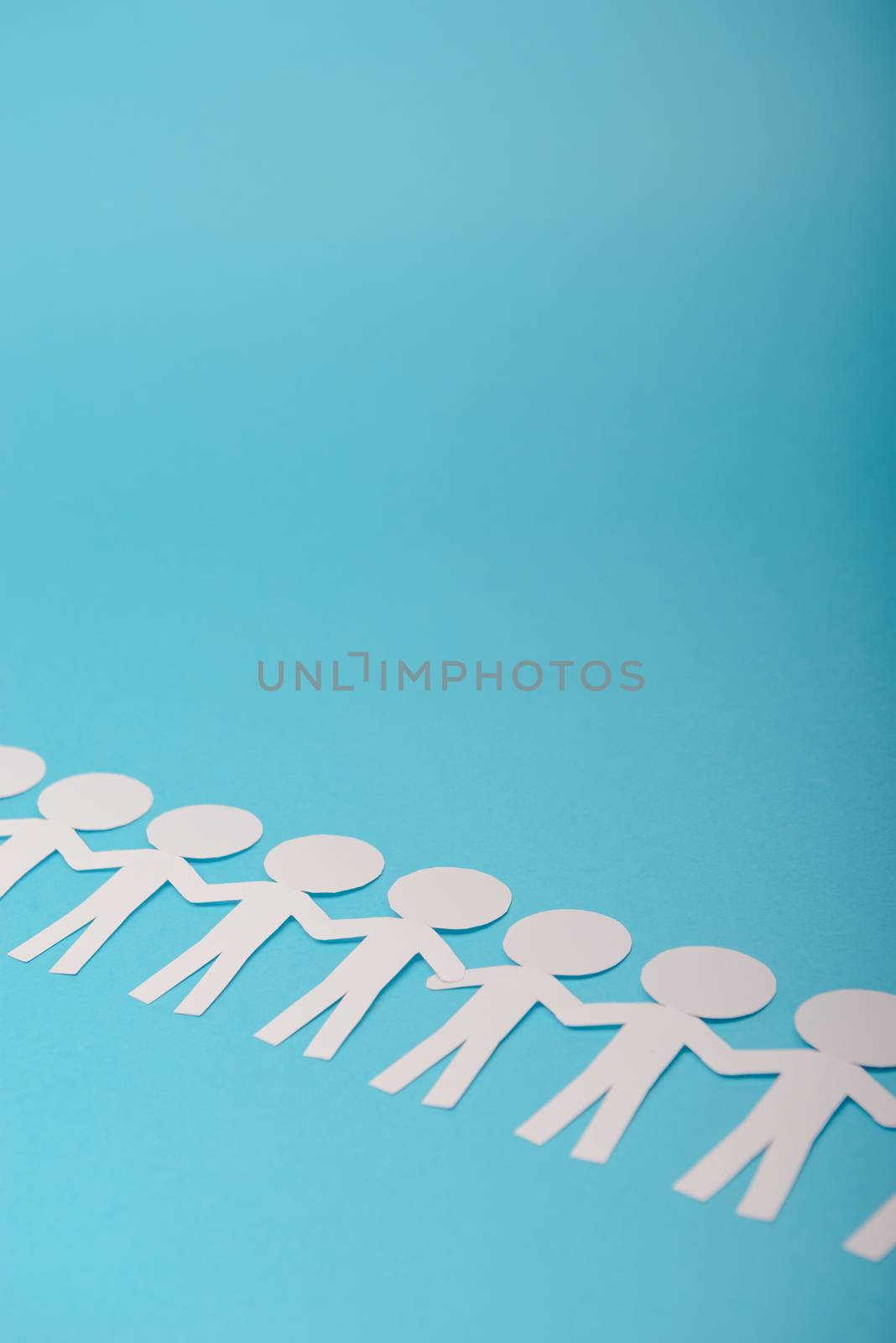 abstract paper people holding for hands on blue background