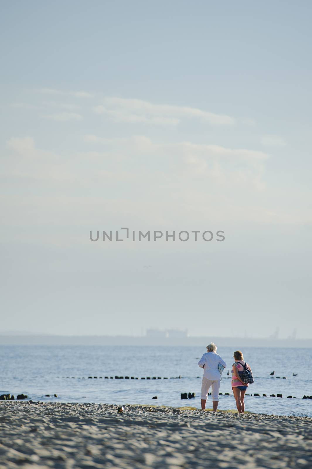 People walking on the beach in the ocean. Summer time