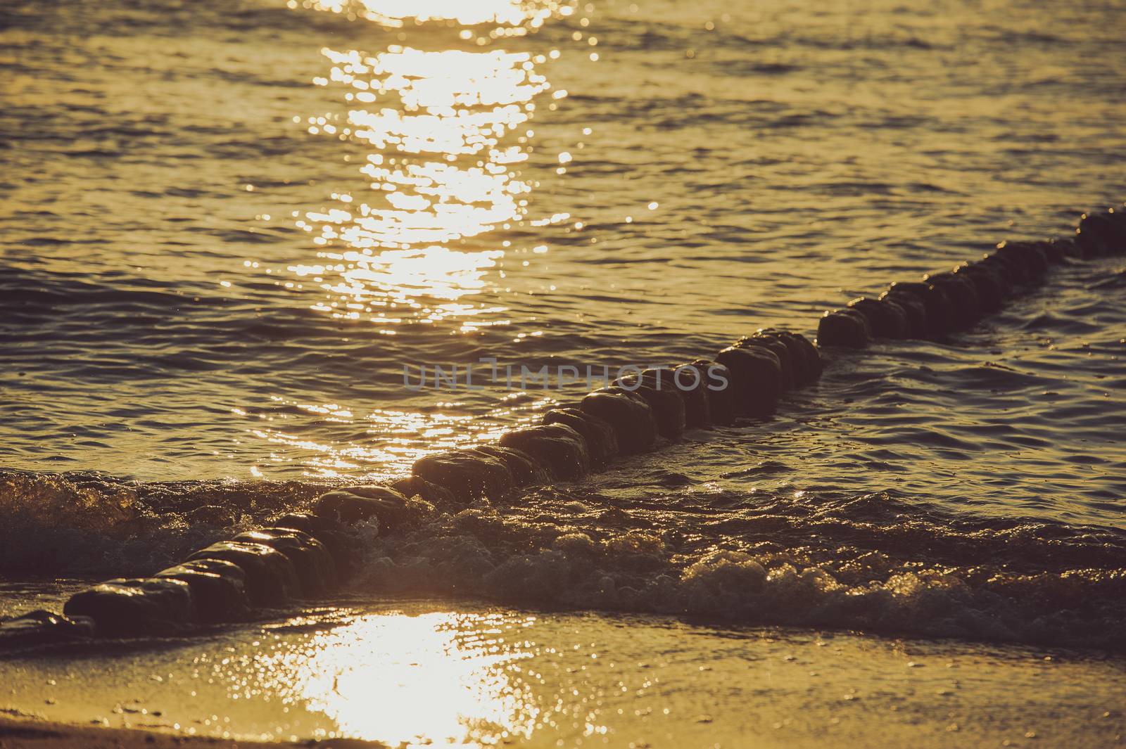 Breakwaters in the Baltic sea over the sunset in summer