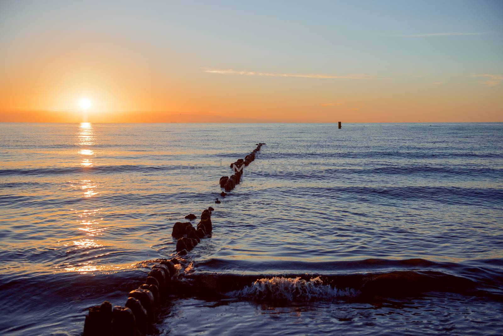 Breakwaters in the Baltic sea over the sunset in summer