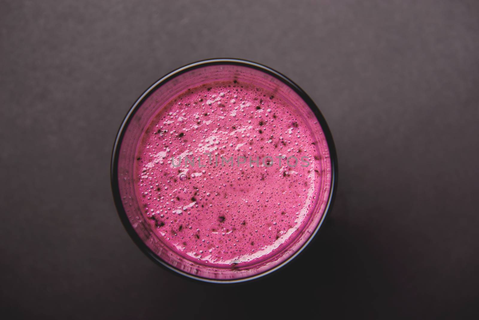 Blueberry smoothie with fresh berries, chia seeds and banana for breakfast on dark background, selective focus