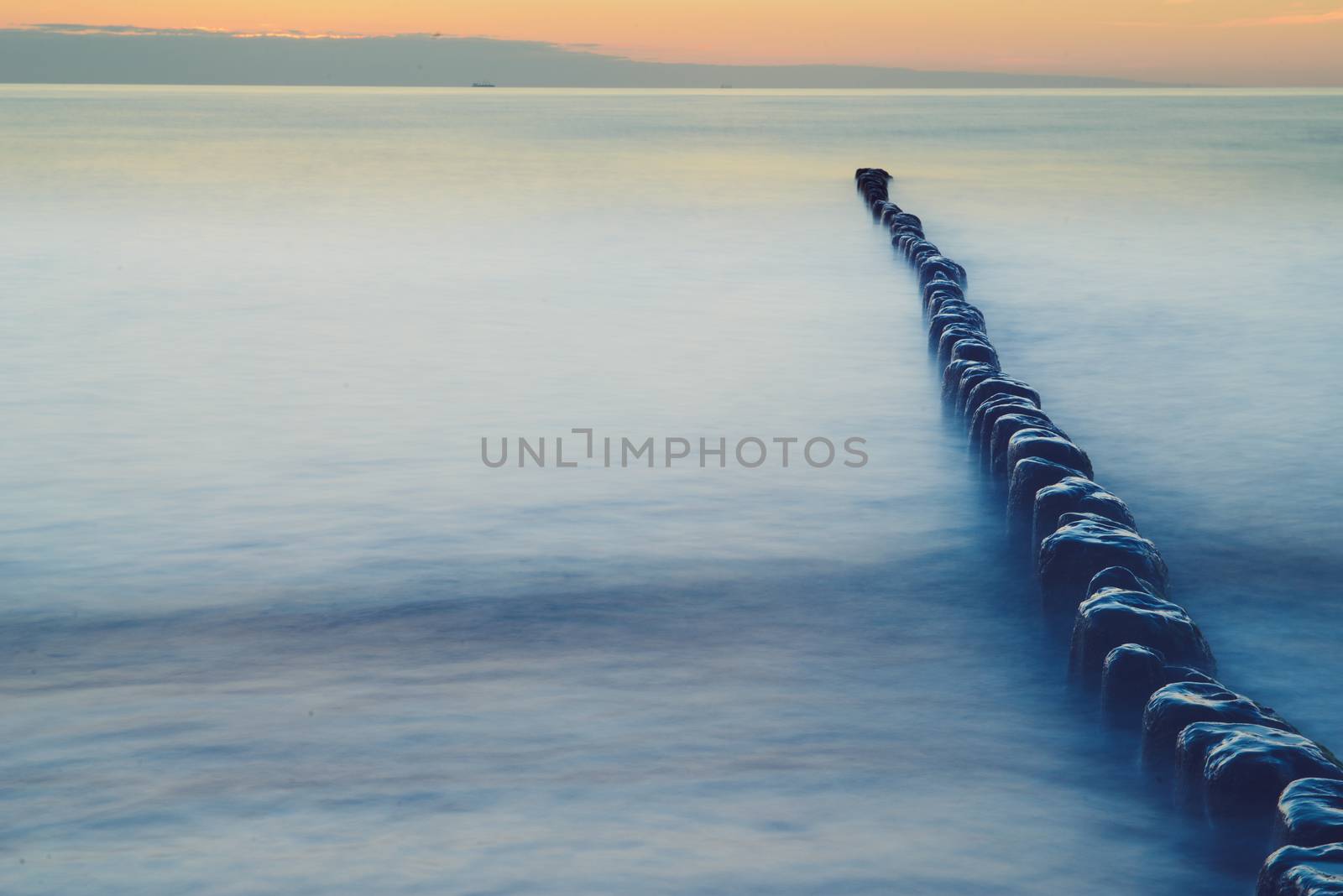 Breakwaters in the Baltic sea over the sunset in summer
